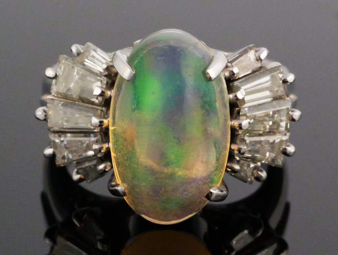 3.5 Ct. Opal & Diamonds Platinum Ring: Platinum ring with 3.47 ct opal flanked with 1.23 cttw diamond baguettes. Size 5-3/4. Weighs 10.7 grams. This item can be shipped in-house. Multiple lot combined shipping may require 3rd Party