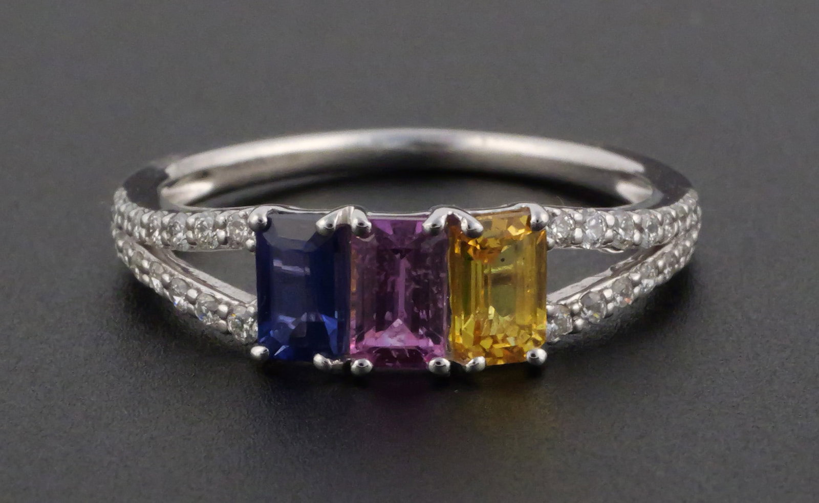 Oscar Friedman Platinum Sapphire Diamond Ring: Oscar Friedman platinum ring set with three emerald-cut natural sapphires in blue, pink and yellow totaling approximately 1.03 ct. and 32 round brilliant-cut diamonds totaling approximately 0.21 ct.,