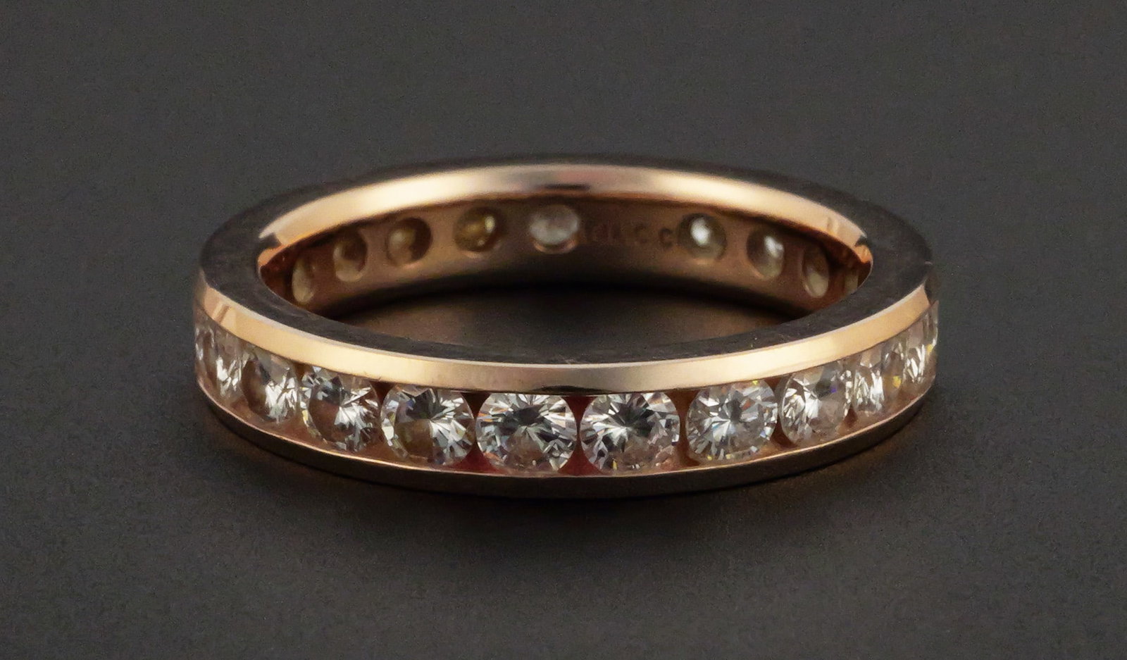 14K Rose Gold 2.00 CTW Moissanite Eternity Ring: 14K rose gold eternity band channel set with round Charles & Colvard Forever One colorless moissanite totaling 2.00 CTW. Includes Charles & Colvard certificate of authenticity and limited warranty car
