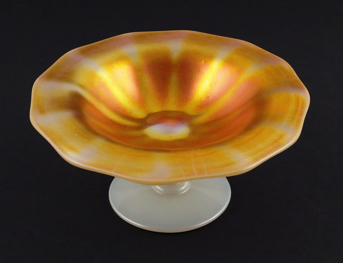 Vintage Steuben Aurene and Calcite Compote Bowl: Vintage Steuben Aurene and Calcite Compote Bowl. Compote has a marigold-to-orange luster interior, scalloped edge and white base. Measures approx 2-3/4" tall x 6-1/4" diameter. This item can be