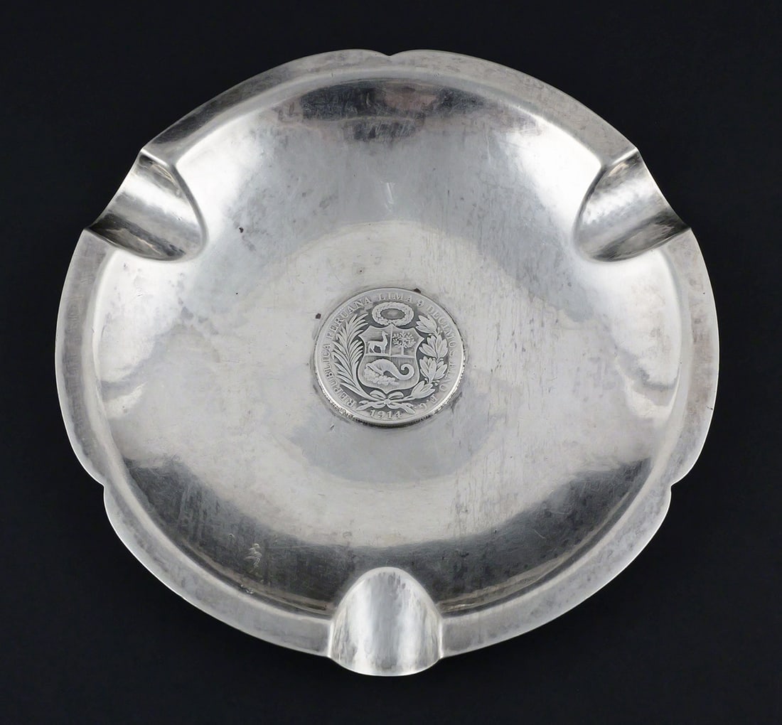 Vintage Peruvian Sterling Silver Ashtray 1914 Coin: Vintage Peruvian Silver Sterling Ashtray with 1914 Peru Coin. Marked on the bottom, "Peru, Welsch, Plata, 925, Amano." Measures approx 6-1/4" diameter. This item can be shipped in-house. Multiple lot