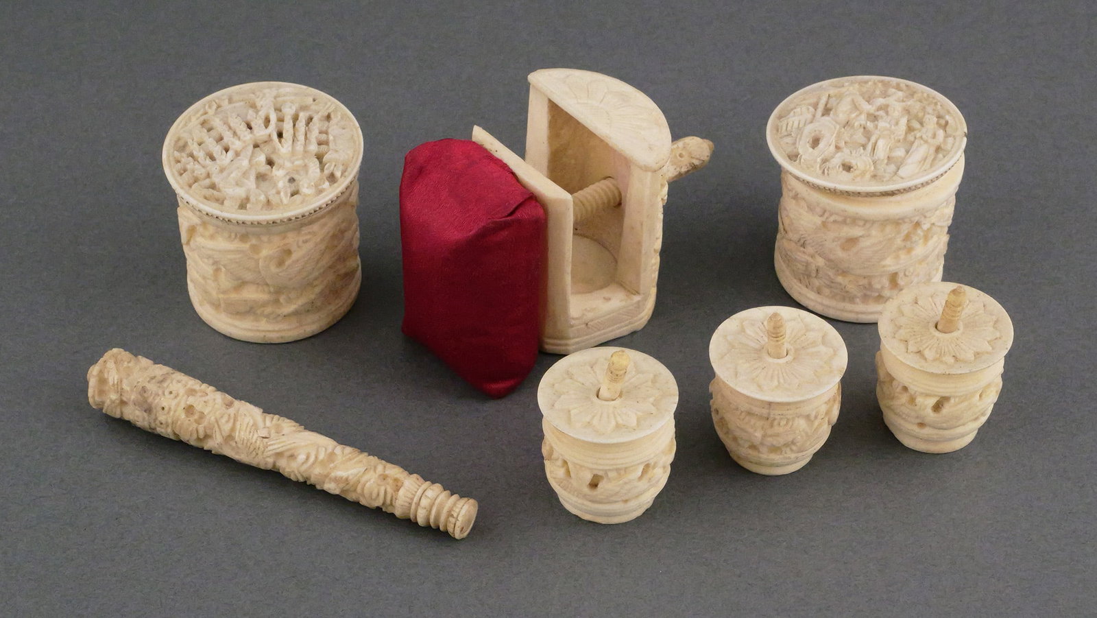 Antique Chinese Carved Bone Sewing Accessories: A group of seven 19th century Victorian Chinese carved bone sewing tools. Sewing clamp pincushion, needle case, three thread winder spool holders or barrels, and two containers. All carved with intric