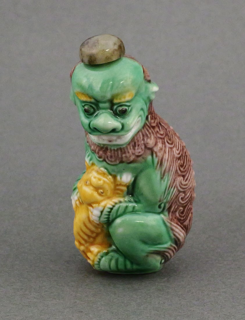 Sancai Glazed Snuff Bottle Foo Lion & Cub: Molded porcelain snuff bottle in the form of a foo lion and cub in the traditional sancai colored glaze. Approx. 2-3/4"L. This item can be shipped in-house. Multiple lot combined shipping may require