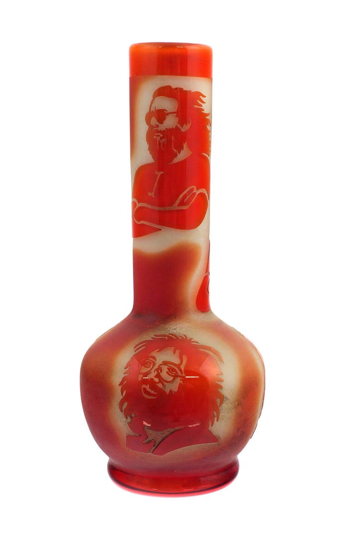 Jerry Garcia Cameo Art Glass Vase: Cameo art glass vase featuring multiple portrait images of Jerry Garcia of the Grateful Dead, rendered in red-orange overlay against a frosted white ground. Tall cylindrical neck over a rounded body. 