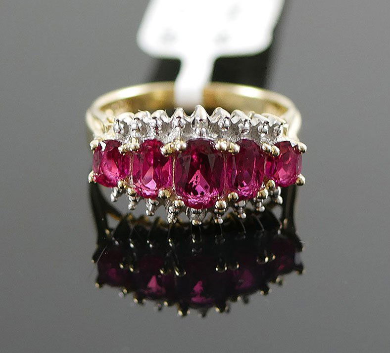 10K RUBY AND DIAMOND RING: 5 SYNTHETIC RUBIES WITH A TOTAL WEIGHT OF APROX. 1.60 CARATS AND 2 SMALL ACCENT DIAMONDS. SIZE 5 AND WEIGHS 3.2 GRAMS.