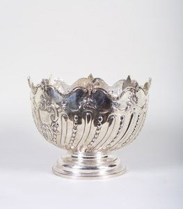 A late Victorian circular punch bowl with applied: A late Victorian circular punch bowl with applied wave scroll and gadroon border, wavy rim above spiral fluted and chased body on a circular foot. London silver 1893, Charles Stuart Harris.