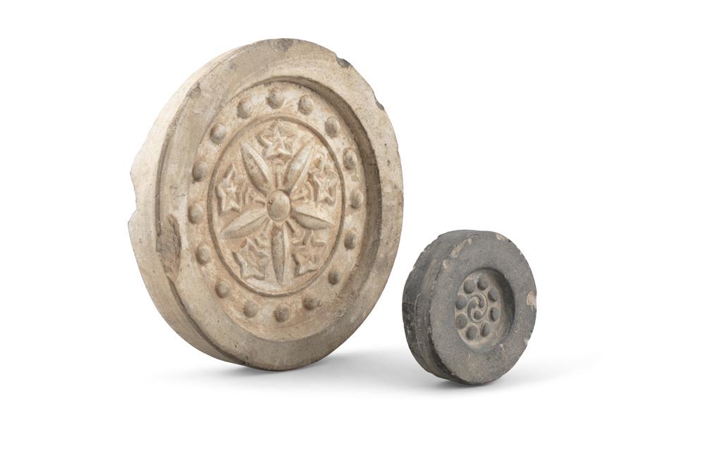 A GROUP OF TWO (2) STONEWARE RIDGE-END ROOF TILES: A GROUP OF TWO (2) STONEWARE RIDGE-END ROOF TILES Korea, Joseon Dynasty With a moulded decor of stylised flowers. Diameter (the biggest): 27cm Provenance: > Private collection; > Former collection of 