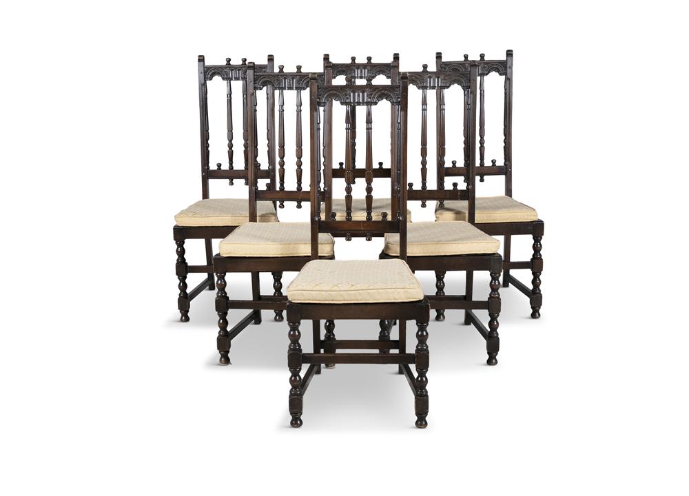 A SET OF SIX ERCOL OLD COLONIAL HIGH-BACK CARVED DINING: A SET OF SIX ERCOL OLD COLONIAL HIGH-BACK CARVED DINING CHAIRS, with original covered snap fastened seat pads, the carved backs, raised on turned legs and stretchers. 111cm high