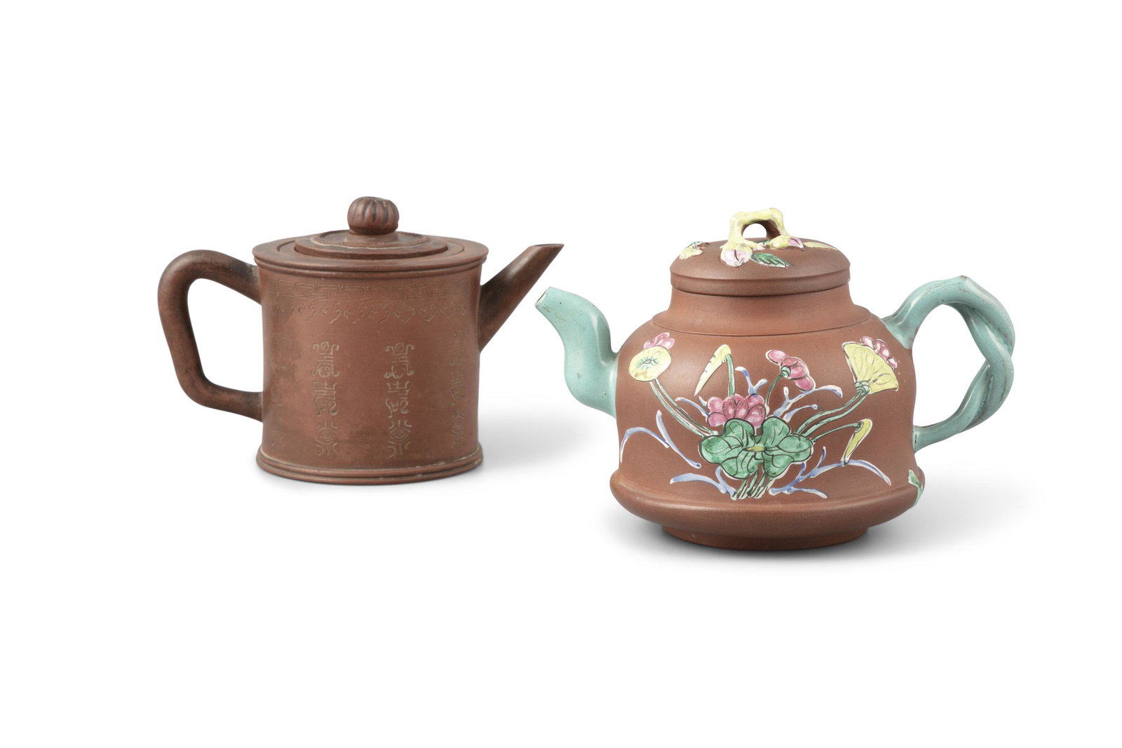 A GROUP OF TWO (2) YIXING TEAPOTS China The first one: A GROUP OF TWO (2) YIXING TEAPOTS China The first one made on brown clay inscribed with Shou / longevity characters, a mark stamped to its base reading ‘宜興紫砂茶&