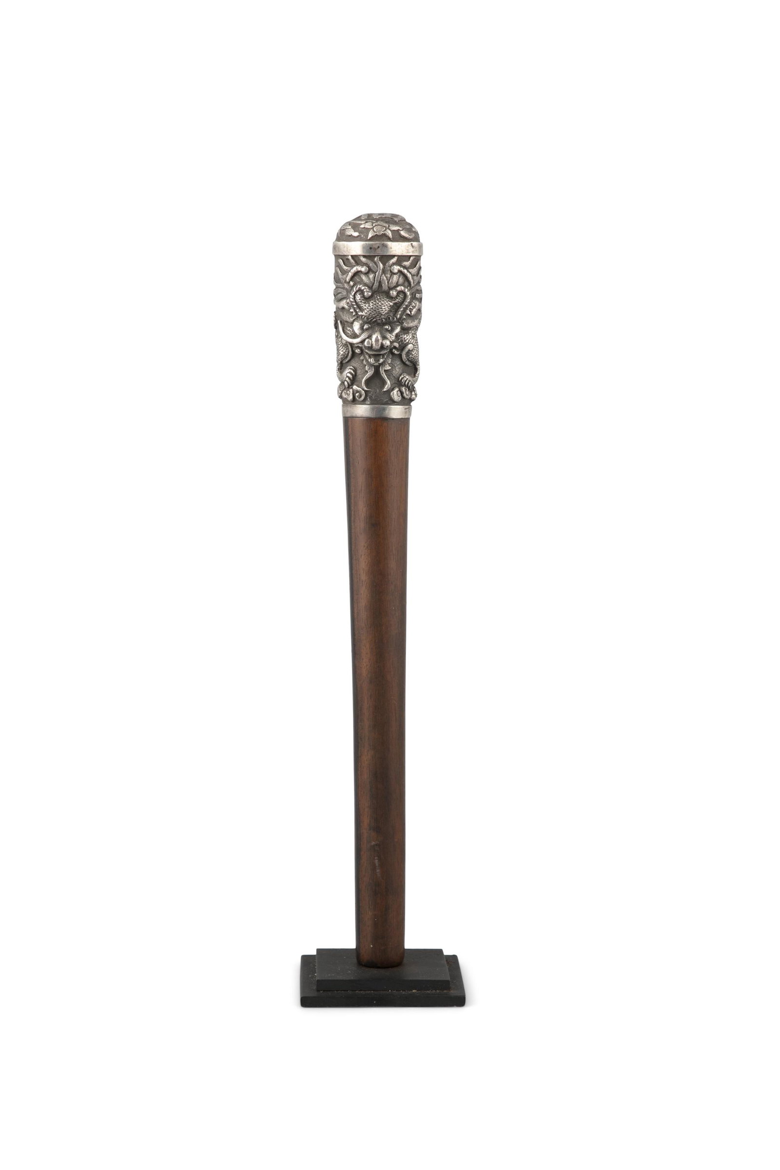 A FRAGMENT OF A WALK STICK ENHANCED WITH A DEEPLY: A FRAGMENT OF A WALK STICK ENHANCED WITH A DEEPLY CHISELLED ‘DRAGON’ SILVER GRASP Vietnam, Circa 1900s-1930s Offered at auction with a modern stand for presentation. H: 27,7 cm
