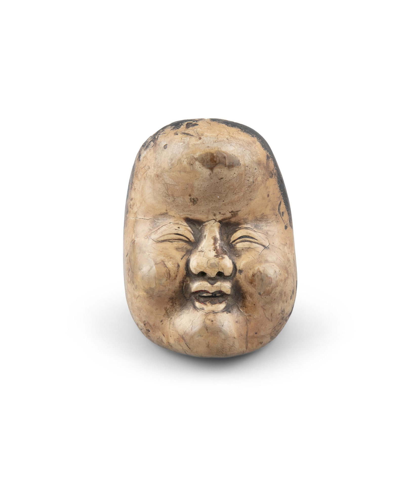 A WOOD NETSUKE OF OKAME Japan, 19th century Shaped as a: A WOOD NETSUKE OF OKAME Japan, 19th century Shaped as a face of Okame, the back inscribed with a signature reading Deme Uman. Offered at auction together with a modern stand to exhibit it. H: 5,5 cm N