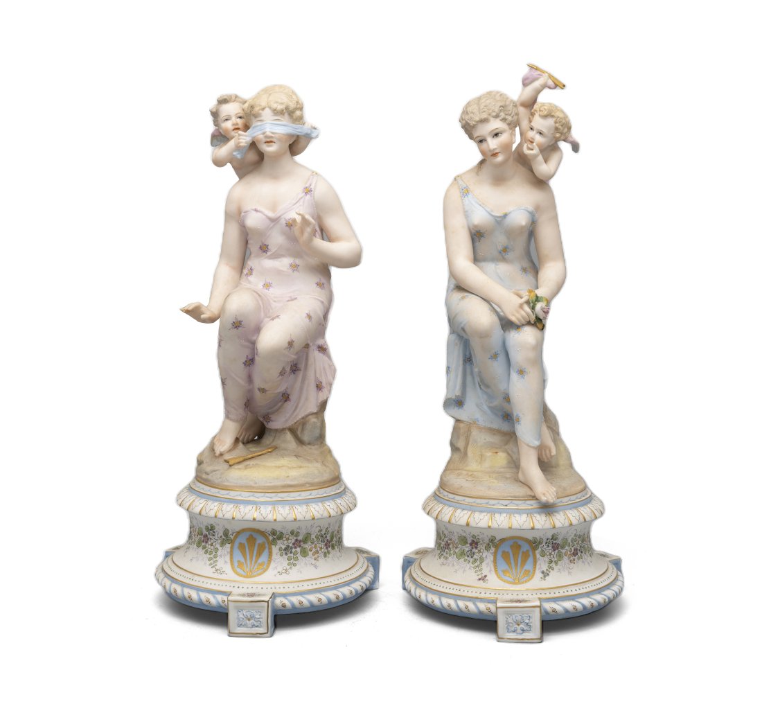 A PAIR OF CONTINENTAL POLYCHROME BISQUE FIGURES, of seated maidens with attendant winged putti, (1 of 1)