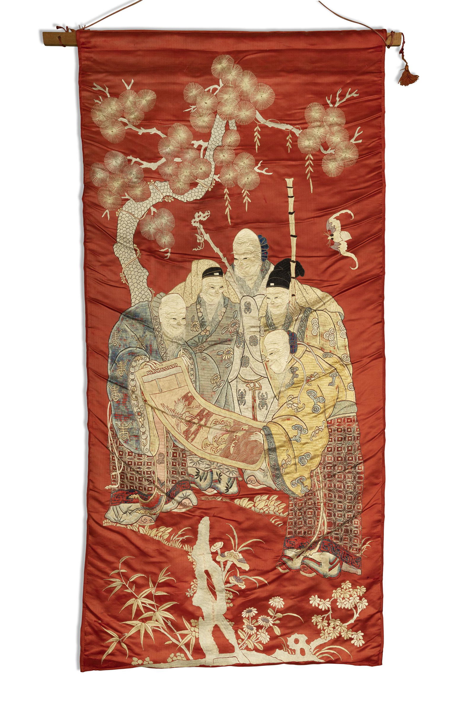 A CHINESE CORAL GROUND SILK PANEL, C.1900  Woven with a group of immortals standing under a pine (1 of 1)
