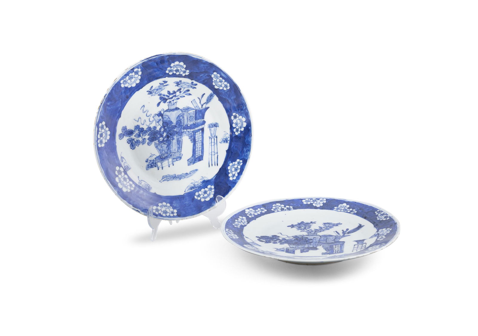 A NEAR PAIR OF CHINESE BLUE AND WHITE '100 ANTIQUES' PATTERN DISHES each of shallow circular form,: A NEAR PAIR OF CHINESE BLUE AND WHITE '100 ANTIQUES' PATTERN DISHES each of shallow circular form, decorated to the interior with flower vases, stands and other precious objects, contained within a br