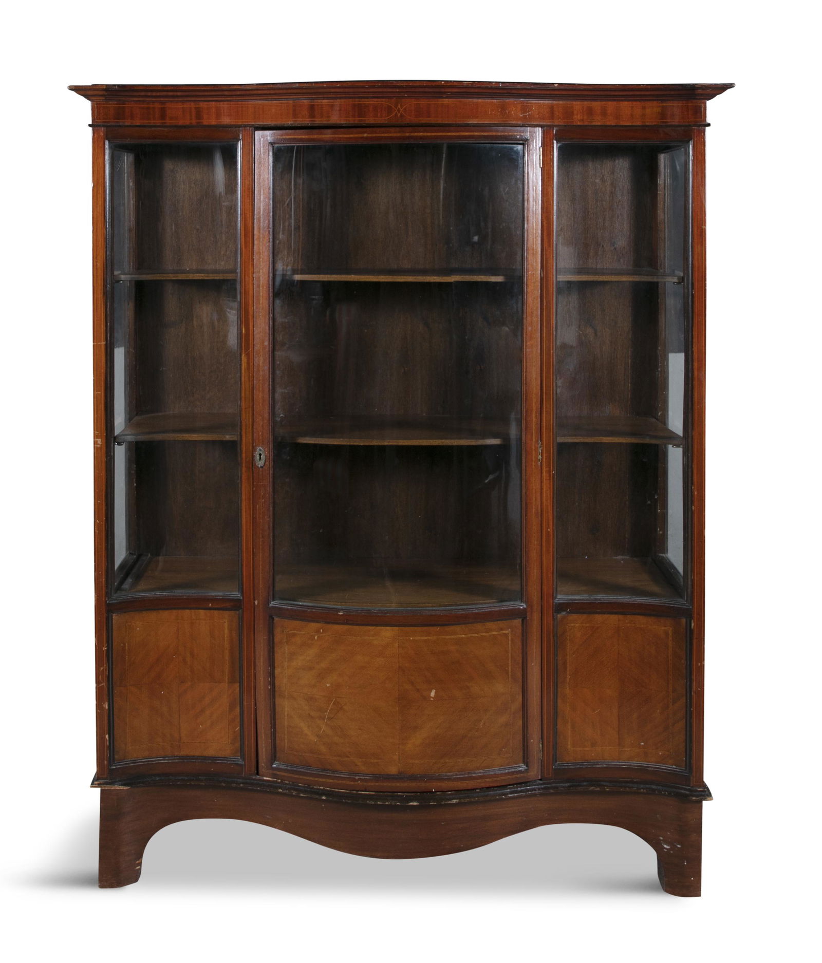 AN EDWARDIAN MAHOGANY SERPENTINE DISPLAY CABINET,  the moulded cornice above three glazed doors with (1 of 2)
