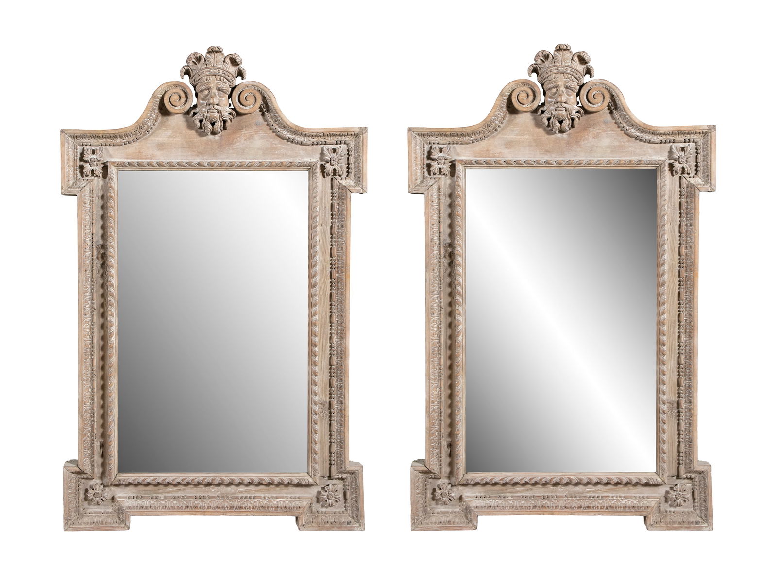 A PAIR OF PINEWOOD PIER MIRRORS IN THE STYLE OF WILLIAM KENT, the broken scrolled pediments filled: A PAIR OF PINEWOOD PIER MIRRORS IN THE STYLE OF WILLIAM KENT, the broken scrolled pediments filled with bearded and feather crowned masks above circular frame with egg and dart mouldings. 137cm high,