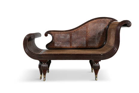 A 19TH CENTURY CARVED HARDWOOD ANGLO INDIAN CAMPAIGN BERGERE SETTEE, with pull-out extending end, : A 19TH CENTURY CARVED HARDWOOD ANGLO INDIAN CAMPAIGN BERGERE SETTEE, with pull-out extending end, with a fluted frame, raised on short demi-fluted tapered legs, with brass castors. 132cm long, 76cm hi