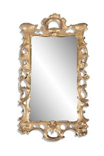 AN IRISH CARVED GILTWOOD WALL MIRROR, C.1750 in rococo style, the rectangular bevelled glass plate: AN IRISH CARVED GILTWOOD WALL MIRROR, C.1750 in rococo style, the rectangular bevelled glass plate, within a surround of c-scrolls, flowerheads and rockwork. 96cm high, 51cm wide