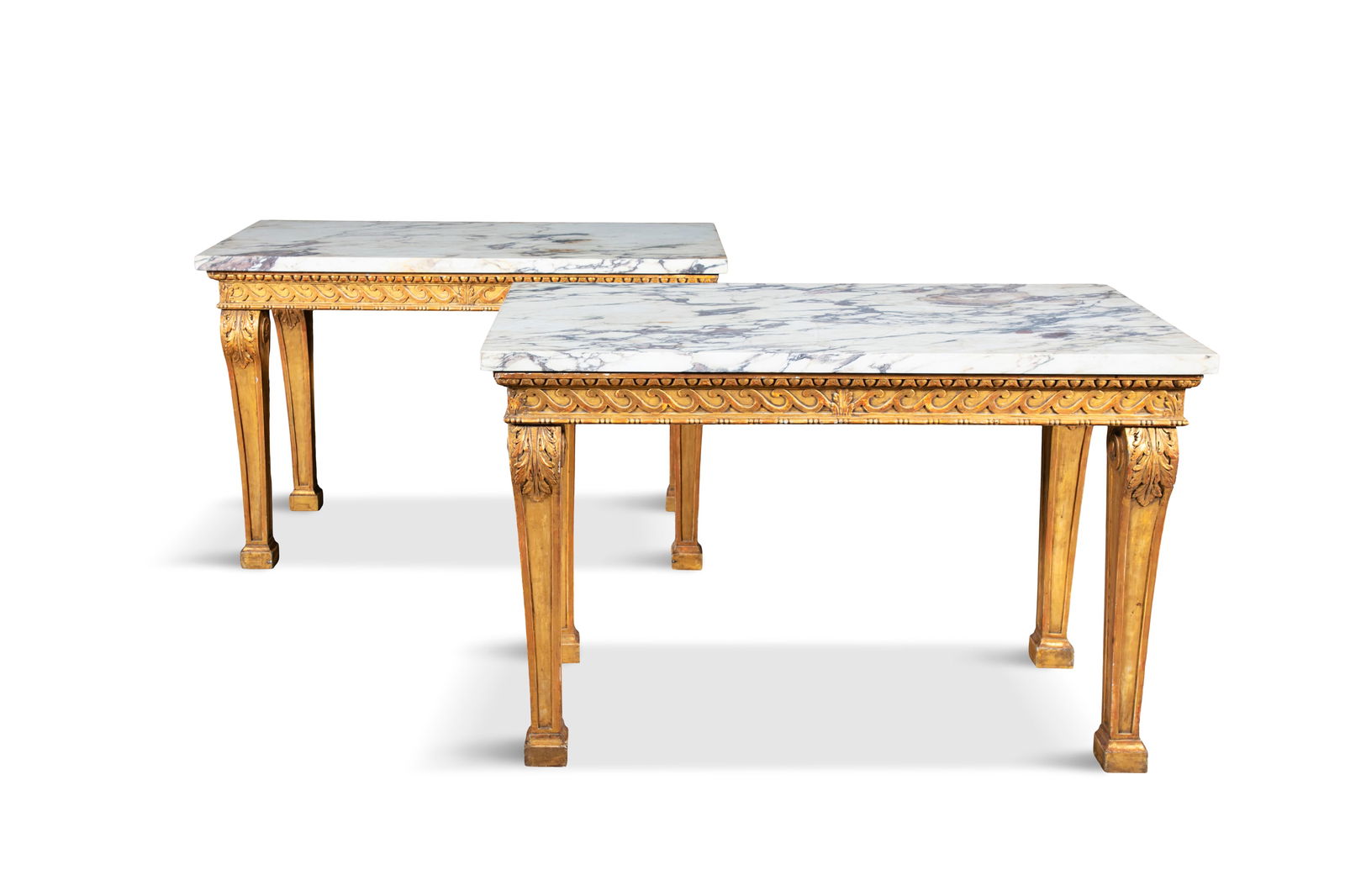 A PAIR OF GILTWOOD AND MARBLE TOP CONSOLE TABLES IN THE STYLE OF WILLIAM KENT, the white variegated: A PAIR OF GILTWOOD AND MARBLE TOP CONSOLE TABLES IN THE STYLE OF WILLIAM KENT, the white variegated rectangular marble tops, above a frieze and opposing Vitruvian scrolls raised on acanthus capped cab