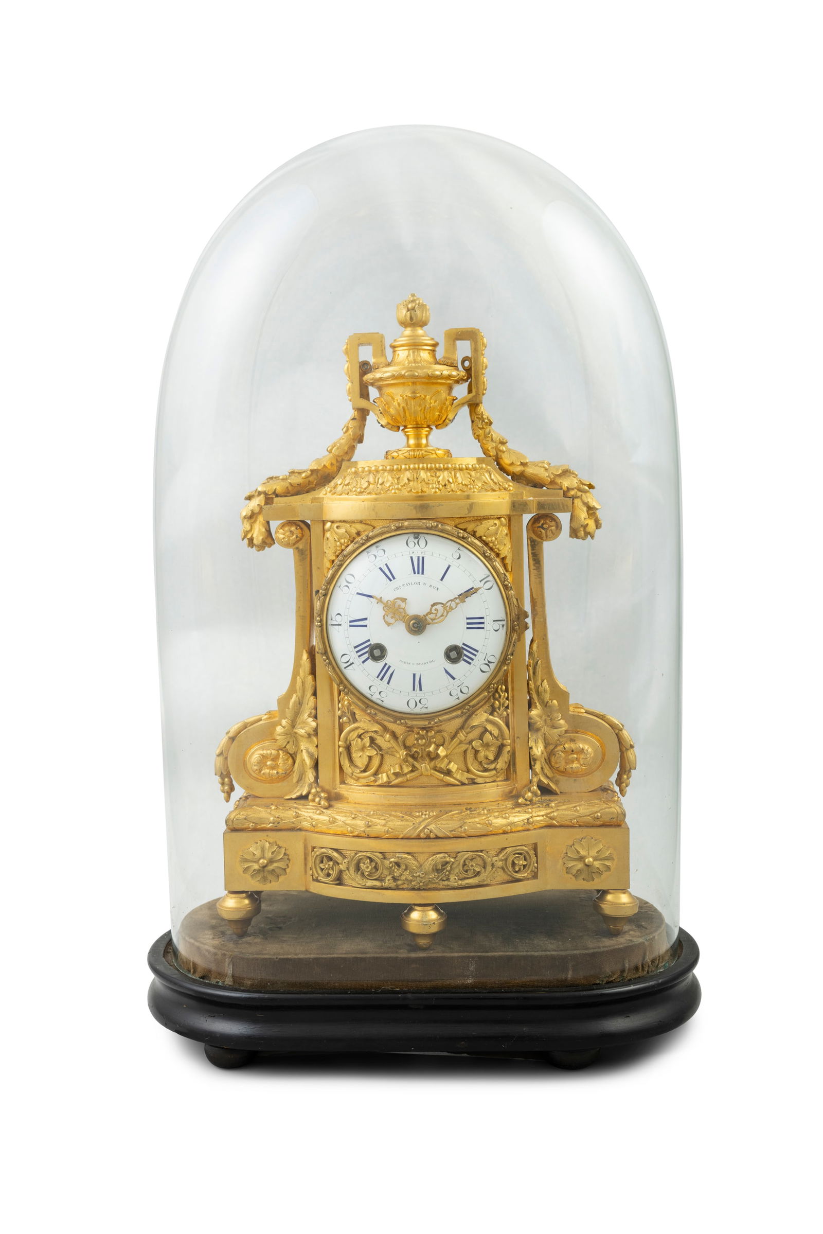 A 19TH CENTURY ORMOLU MANTLE CLOCK BY CHARLES TAYLOR & SON, PARIS & BRISTOL surmounted by a urn fi: A 19TH CENTURY ORMOLU MANTLE CLOCK BY CHARLES TAYLOR & SON, PARIS & BRISTOL surmounted by a urn finial with garland swags, over a circular enamel dial inked with Roman and Arabic numerals, on an break