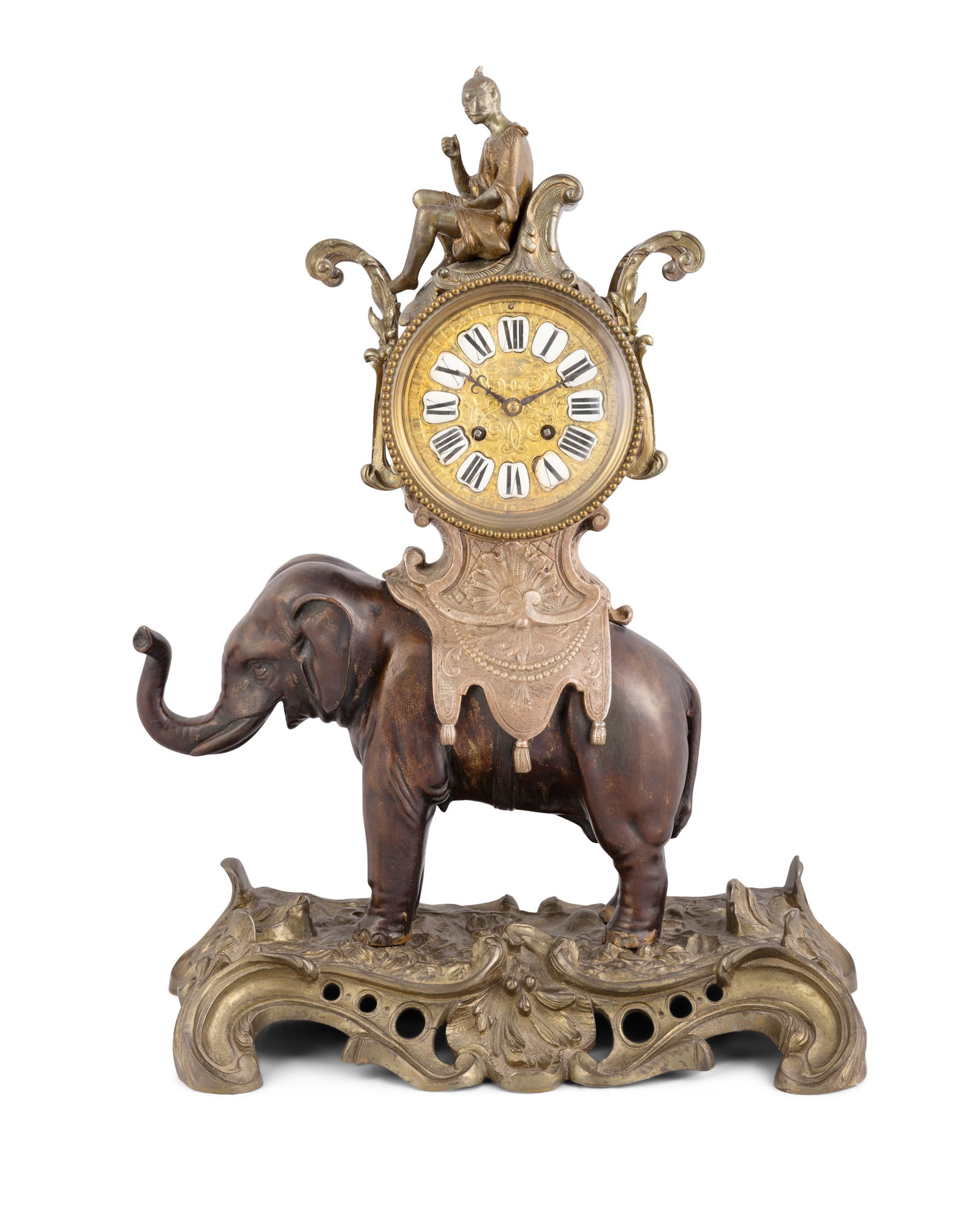 A FRENCH BRONZE AND GILTMETAL CLOCK IN THE FORM OF A CEREMONIAL ELEPHANT CIRCA 1900 the cylindrical: A FRENCH BRONZE AND GILTMETAL CLOCK IN THE FORM OF A CEREMONIAL ELEPHANT CIRCA 1900 the cylindrical clock barrel surmounted by a seated figure on top of a Howdah and on the back of an elephant, with h