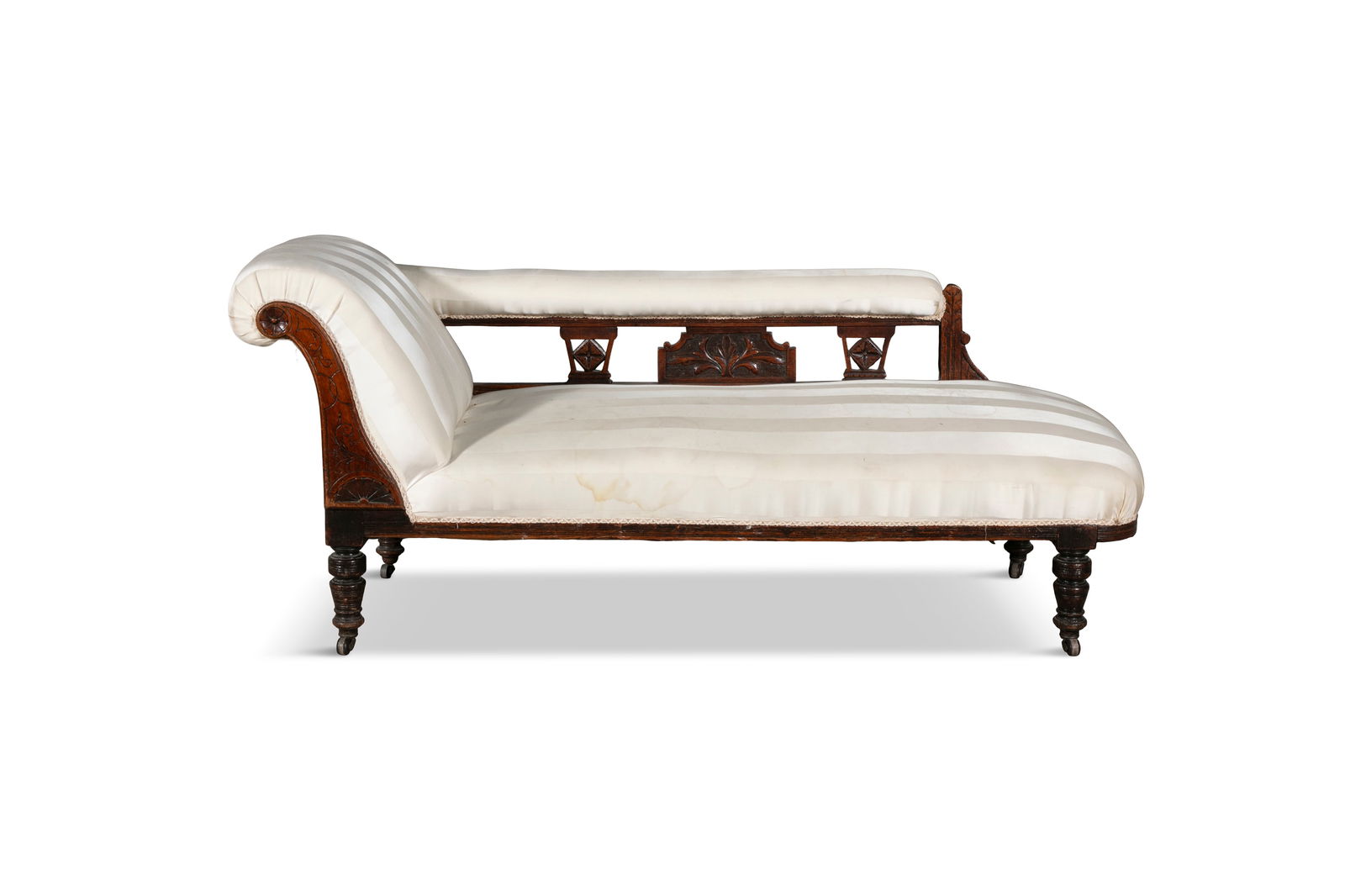 A VICTORIAN MAHOGANY FRAMED SINGLE SCROLL END CHAISE LONGUE, incised line decoration to the upright: A VICTORIAN MAHOGANY FRAMED SINGLE SCROLL END CHAISE LONGUE, incised line decoration to the upright support, with open back, upholstered in yellow striped silk upholstery, raised on ring turned legs a