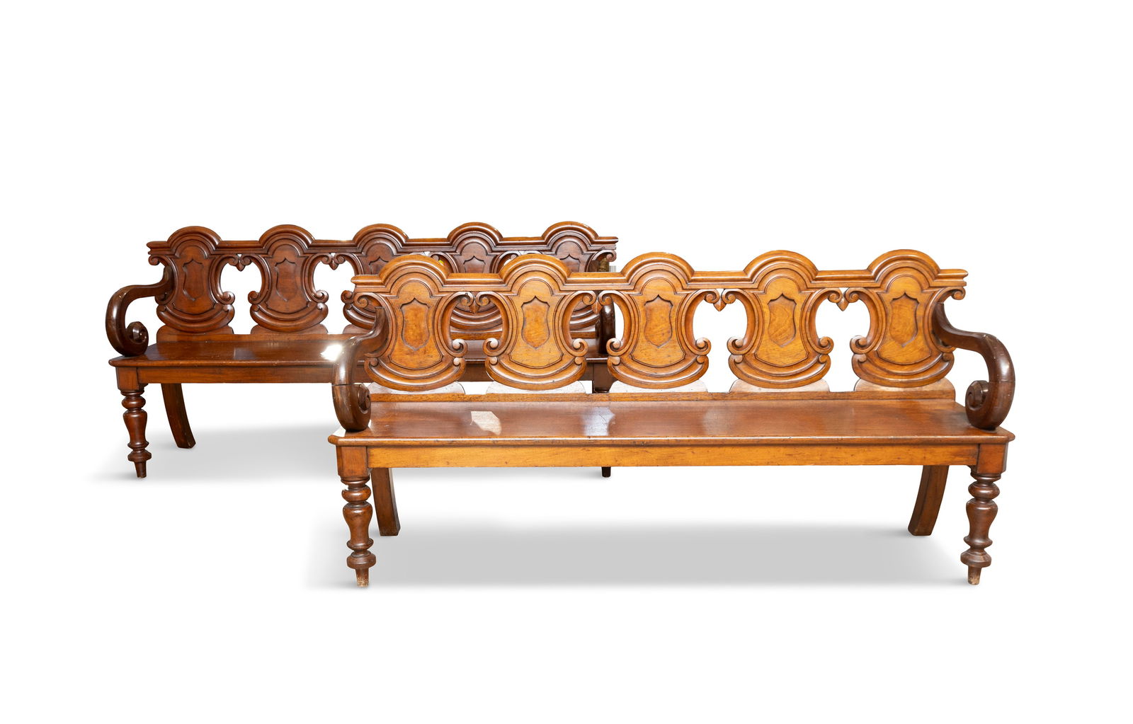 A PAIR OF VICTORIAN MAHOGANY HALL BENCHES with pierced shield shaped backs, solid panel seat,: A PAIR OF VICTORIAN MAHOGANY HALL BENCHES with pierced shield shaped backs, solid panel seat, scroll arms and raised on turned baluster supports. 86cm high, 176cm wide, 39cm deep