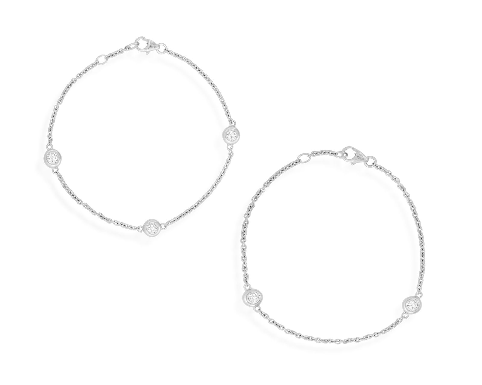 A PAIR OF DIAMOND CHAIN BRACELETS Each fine cable-link chain, interspersed by collet-set: A PAIR OF DIAMOND CHAIN BRACELETS Each fine cable-link chain, interspersed by collet-set brilliant-cut diamonds, mounted in 18K gold, Italian registry mark, lengths 18cm