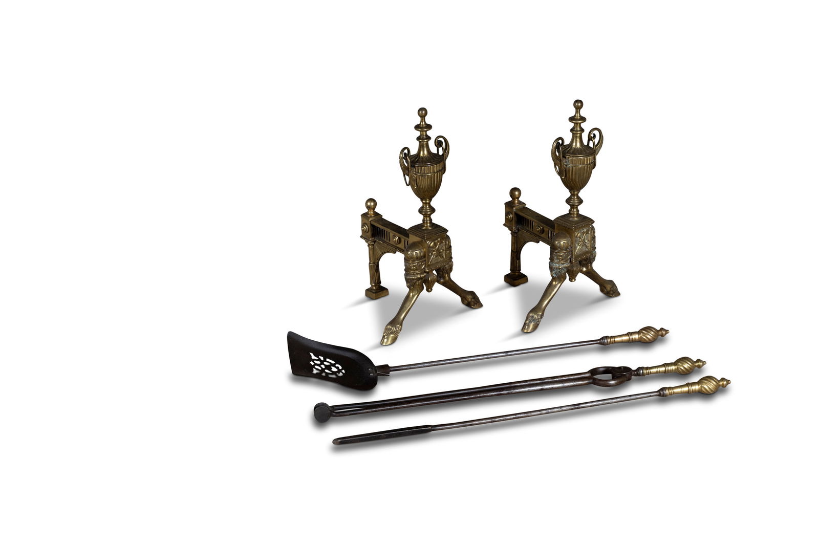 A PAIR OF CAST BRASS ANDIRONS, 19TH CENTURY, of Classical design, with fluted urn and splayed legs: A PAIR OF CAST BRASS ANDIRONS, 19TH CENTURY, of Classical design, with fluted urn and splayed legs with hoof feet, 45cm high; together with a set of three Georgian brass handled fire tools comprising