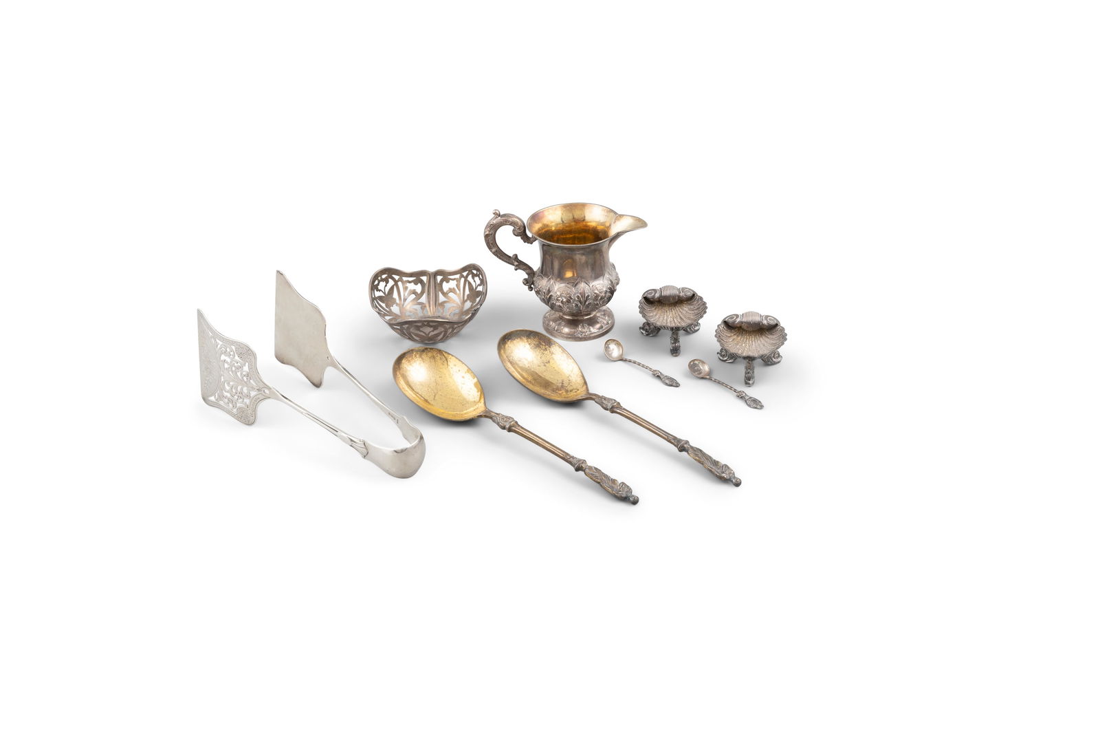 A MISCELLANEOUS COLLECTION OF SILVER, comprising: tongs, Sheffield 1894, a pair of silver scallop: A MISCELLANEOUS COLLECTION OF SILVER, comprising: tongs, Sheffield 1894, a pair of silver scallop shell salts with spoons, Chester, 1895, a bonbon basket, London 1912, a cream jug, London 1836, a pair