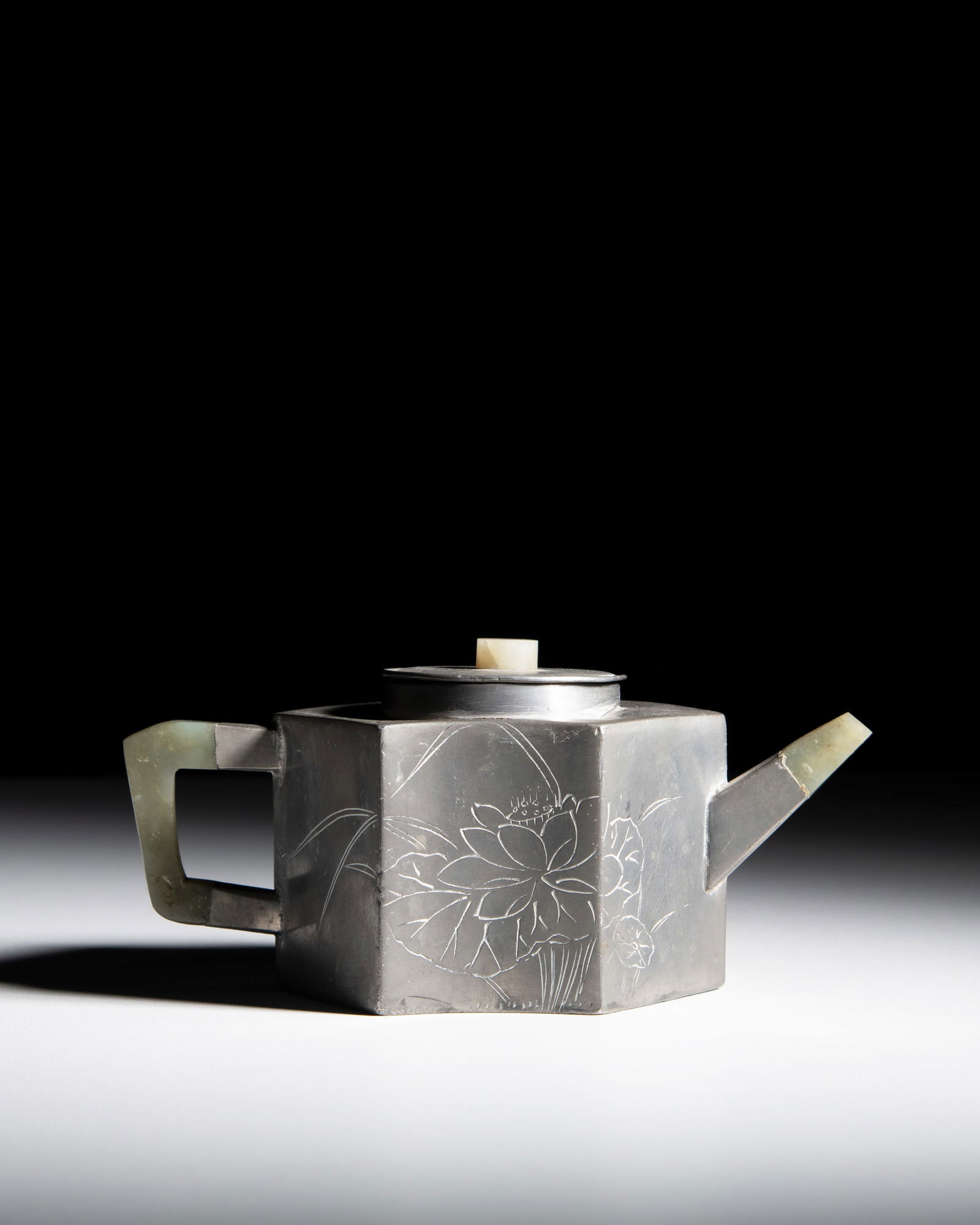 A YIXING PEWTER TEAPOT,SIGNED SONG LU ZENG LI with jade fittings and decorated with poetic: A YIXING PEWTER TEAPOT,SIGNED SONG LU ZENG LI with jade fittings and decorated with poetic inscriptions and lotus designs to the side. H.10cm W.20cm China, late 19th century