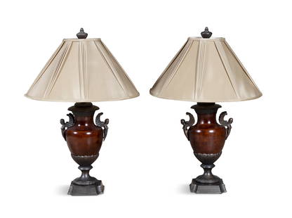 A PAIR OF BRONZED URN-SHAPED TABLE LAMPS, each with winged figural side handles, fitted with: A PAIR OF BRONZED URN-SHAPED TABLE LAMPS, each with winged figural side handles, fitted with cream shades, 87cm high