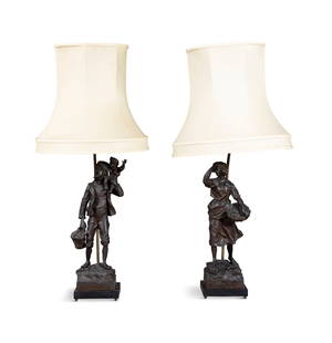 A PAIR OF ITALIAN BRONZED METAL FIGURAL TABLE LAMPS, EARLY 20TH CENTURY, modelled as male and: A PAIR OF ITALIAN BRONZED METAL FIGURAL TABLE LAMPS, EARLY 20TH CENTURY, modelled as male and female figures holding fish baskets and standing on square naturalistic bases, both with cream shades, 79c