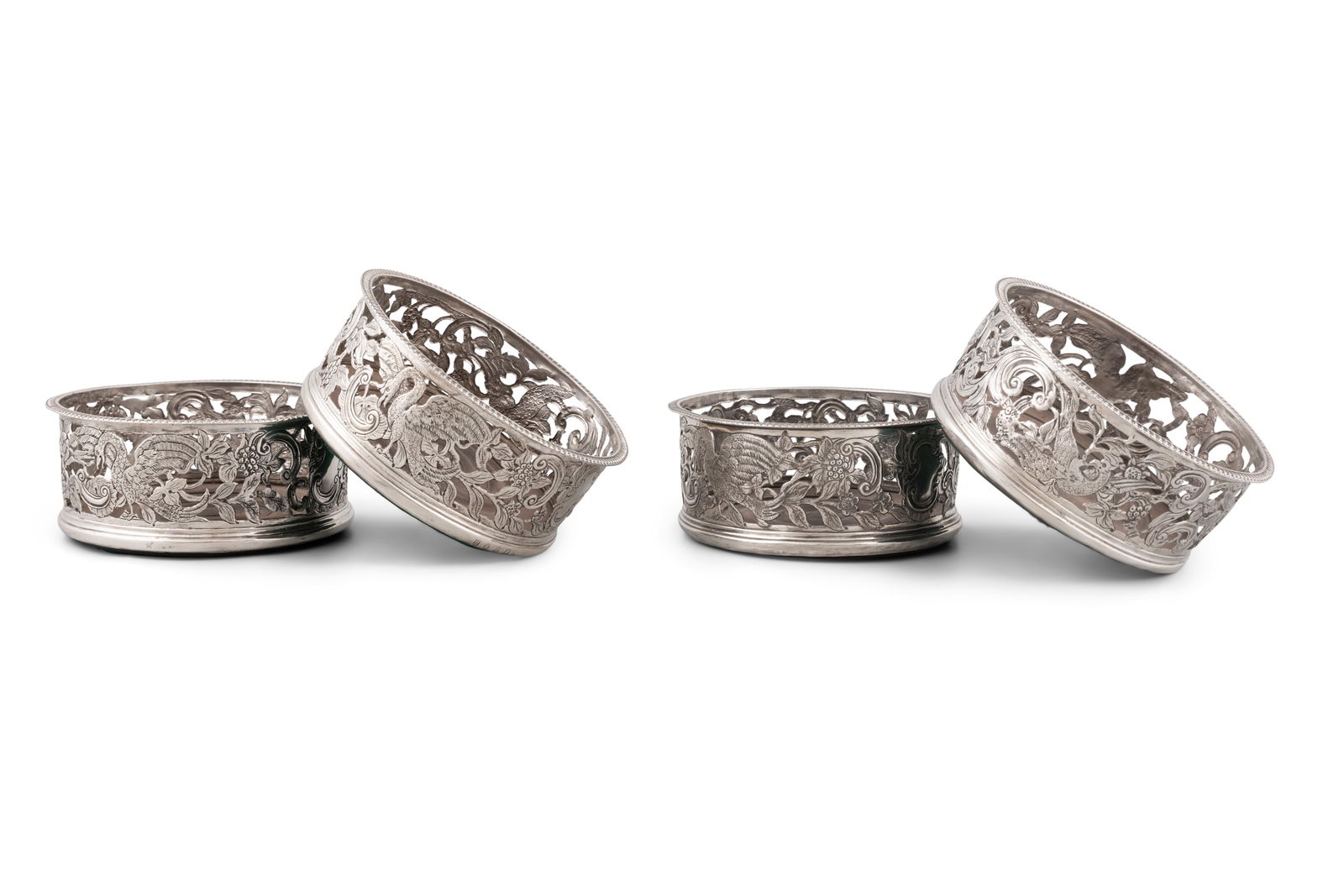 A SET OF FOUR GEORGE III IRISH SILVER COASTERS, Dublin 1813, maker's mark of Michael Flanagan, in: A SET OF FOUR GEORGE III IRISH SILVER COASTERS, Dublin 1813, maker's mark of Michael Flanagan, in the rococo taste, each of circular shape with out-turned egg and dart rim, the pierced bodied chased a