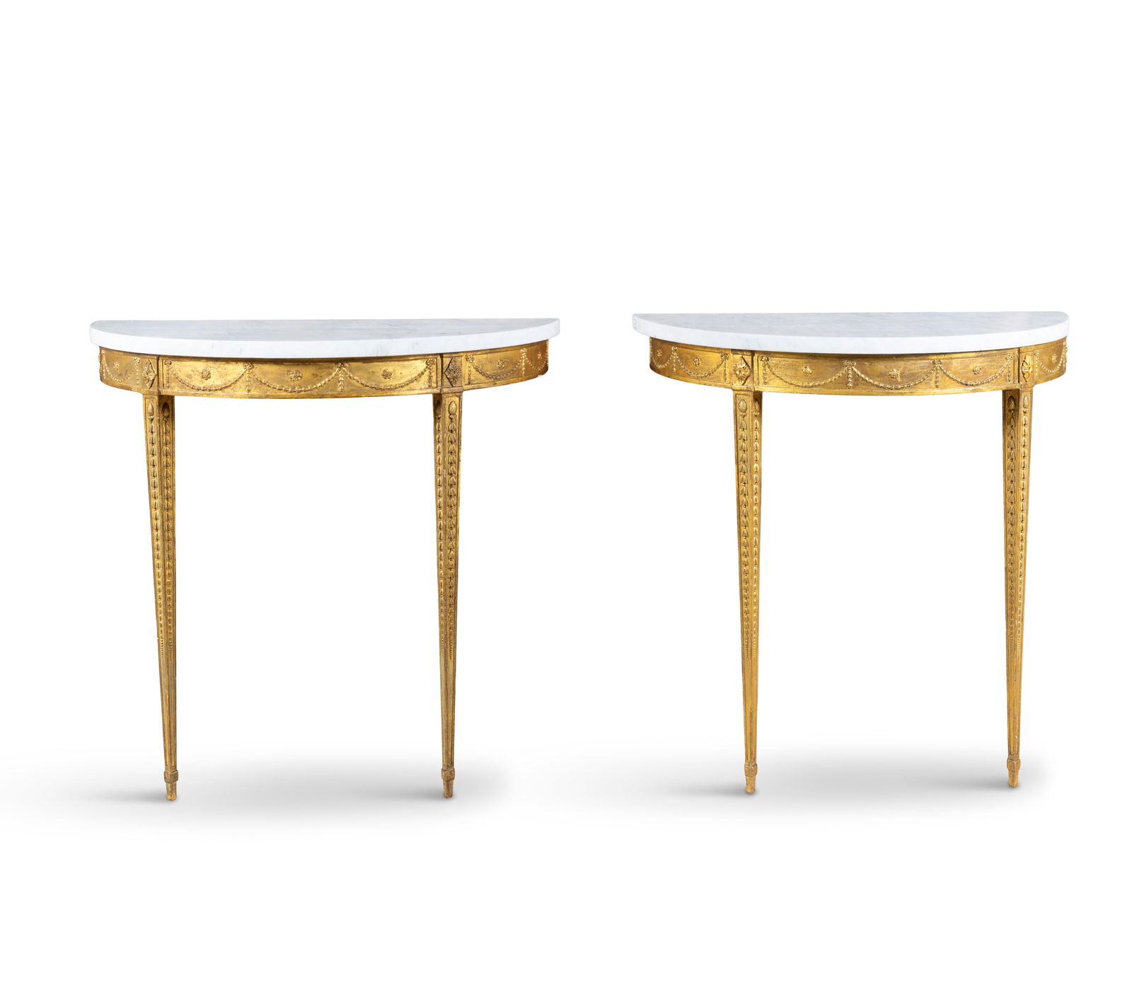 A PAIR OF GEORGE III GILTWOOD DEMI-LUNE CONSOLE TABLES the friezes decorated with ribbon tied: A PAIR OF GEORGE III GILTWOOD DEMI-LUNE CONSOLE TABLES the friezes decorated with ribbon tied swags, on tapering legs, with associated marble tops. 84.5cm high, 82.2cm wide, 40cm deep