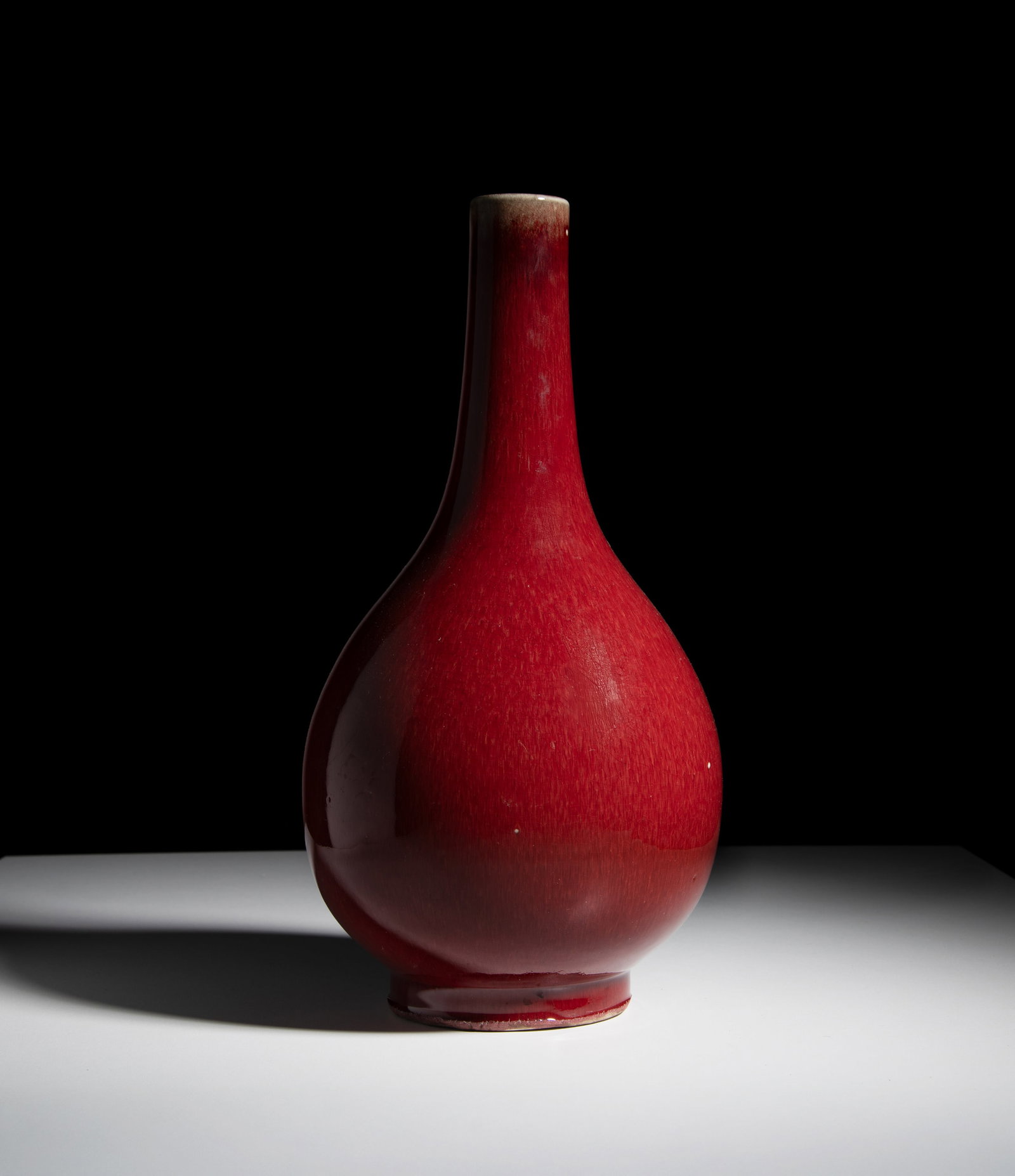 A LANGYAO GLAZED BOTTLE VASE 18-19世纪 郎窑红釉长颈: A LANGYAO GLAZED BOTTLE VASE 18-19世纪 郎窑红釉长颈瓶 China, 18-19th century H.38.5cm