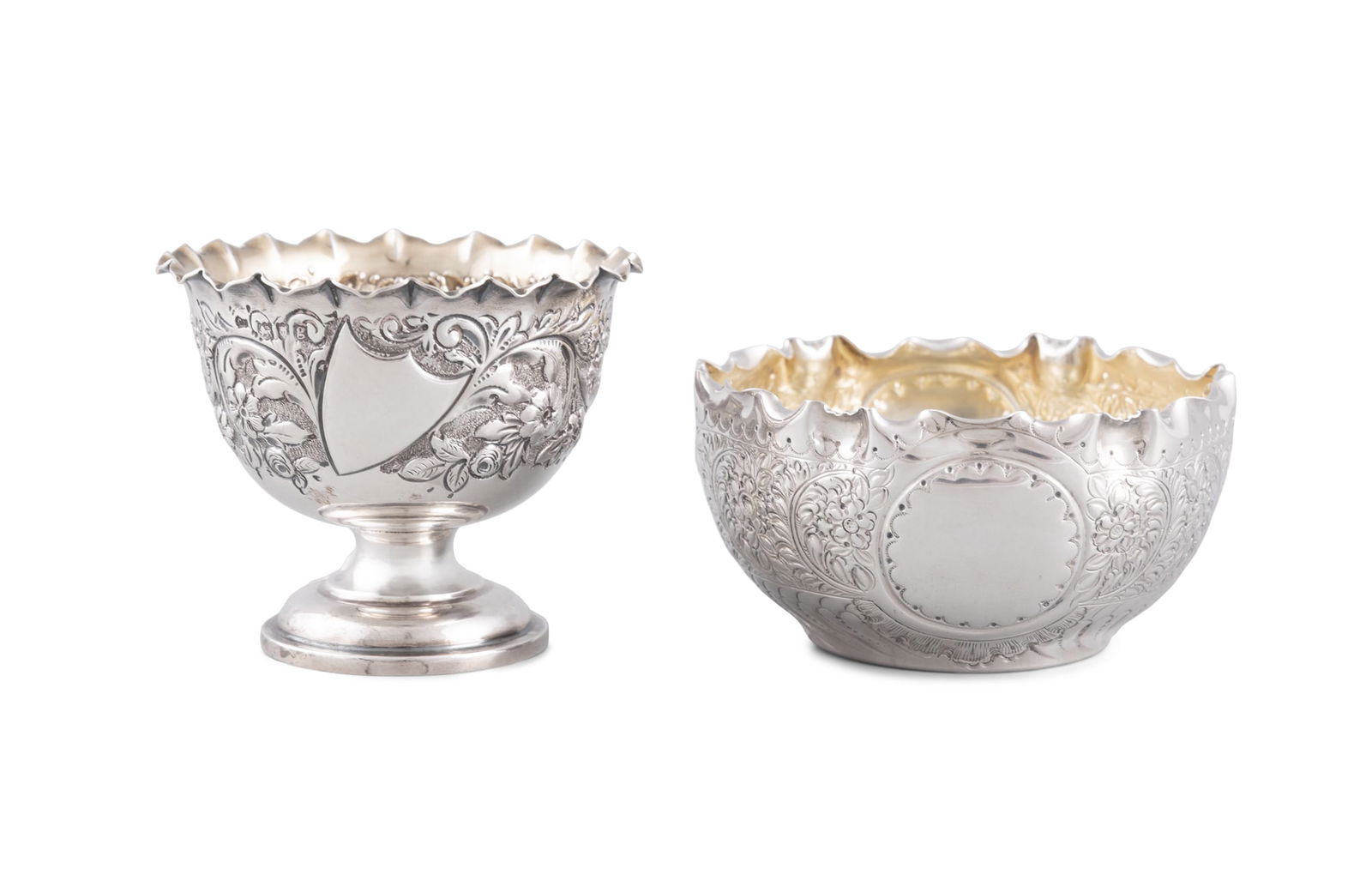 A SILVER GOBLET, London 1902, with wavy rims and body decorated with repousse floral motifs: A SILVER GOBLET, London 1902, with wavy rims and body decorated with repousse floral motifs surrounding an empty cartouche, raised on waisted circular stepped foot, 7.5cm high 9cm diameter; together w