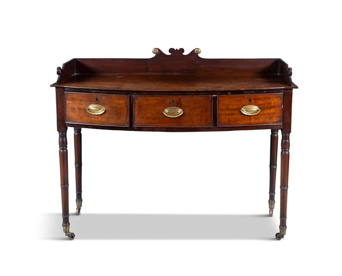 A MAHOGANY BOW-FRONT SIDE TABLE, C.1815 with raised gallery back, over a frieze of three drawers, (1 of 5)