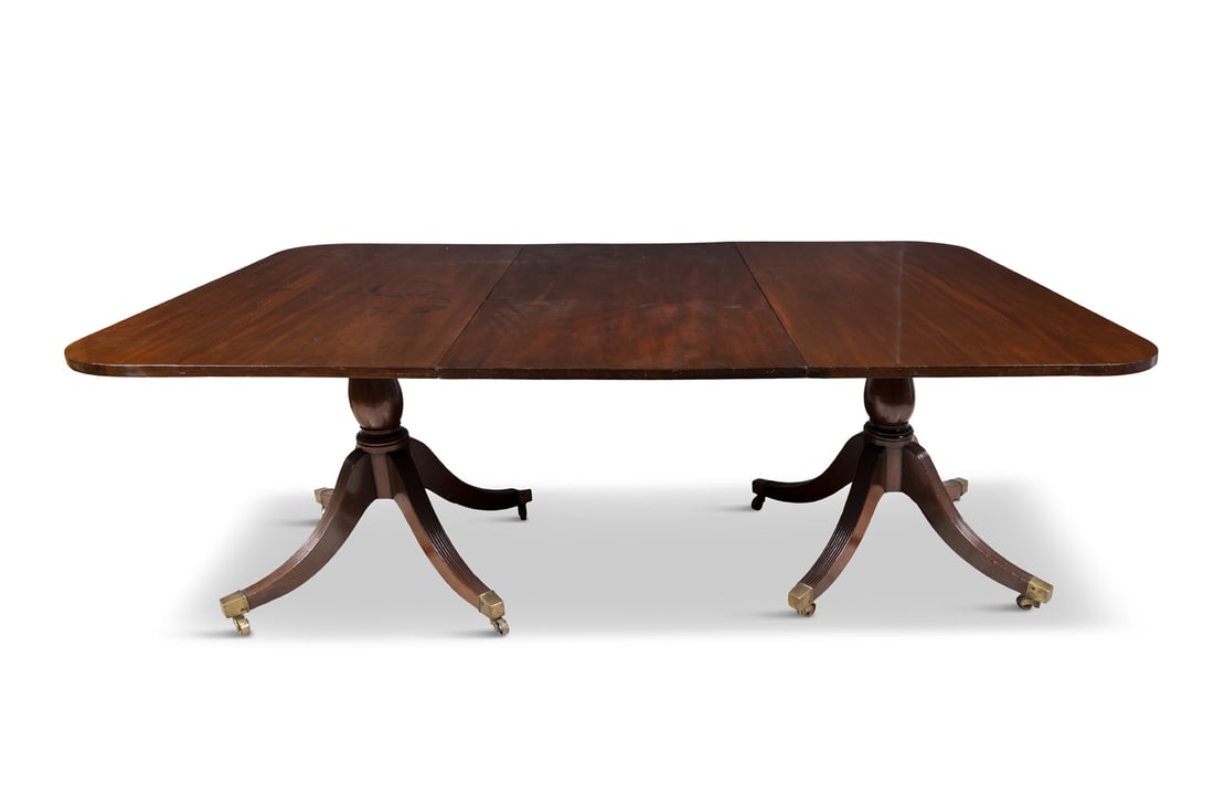 A MAHOGANY EXTENDING DINING TABLE, 19TH CENTURY on twin pillar supports, with downswept reeded legs (1 of 4)