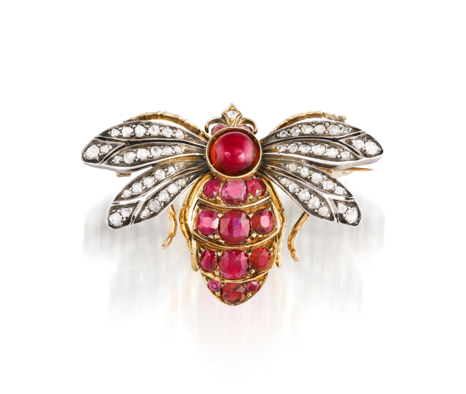 A GEM-SET AND DIAMOND BROOCH Designed as stylised bee, the abdomen set with cushion-shaped rubies a: A GEM-SET AND DIAMOND BROOCH Designed as stylised bee, the abdomen set with cushion-shaped rubies and red spinel, with circular-cut garnet cabochon crown and rose-cut diamond wings, mounted in silver