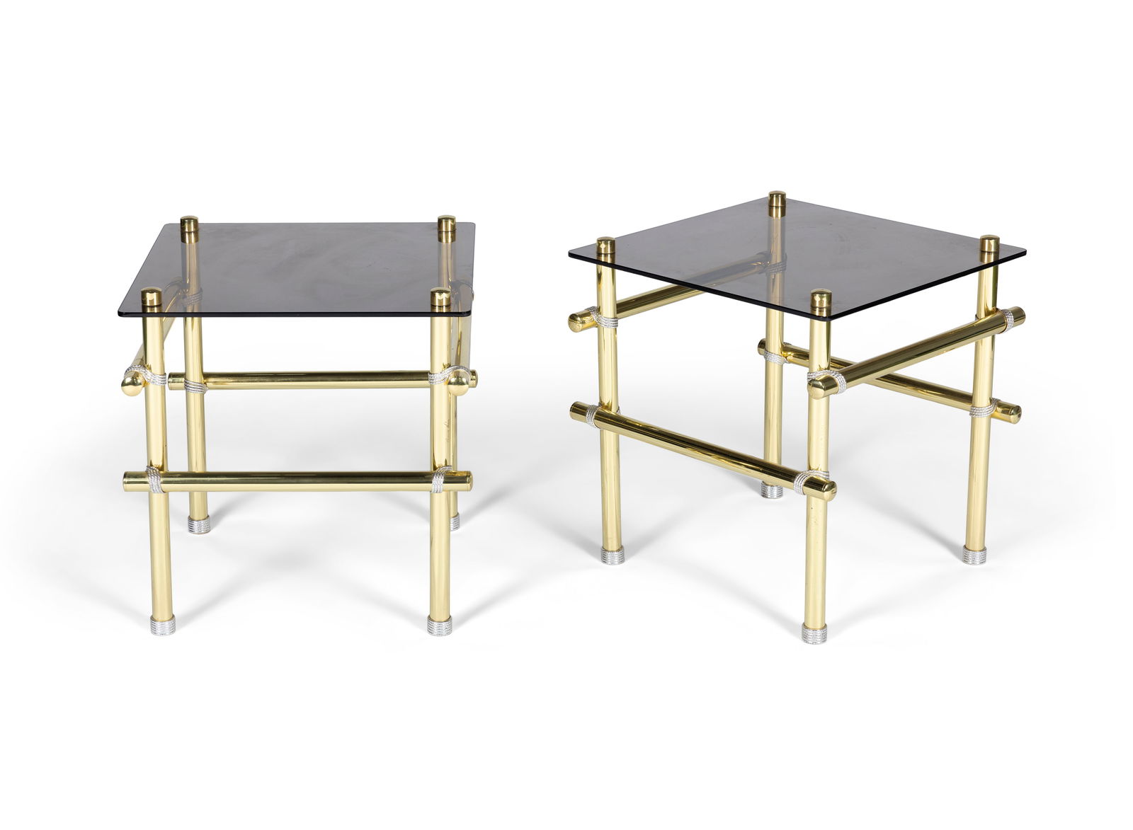 ANNA NORA A pair of gilt metal side tables by Anna Nora, with a smoked glass top. With maker's: ANNA NORA A pair of gilt metal side tables by Anna Nora, with a smoked glass top. With maker's stamp. Italy, 50 x 50 x 51cm (h)