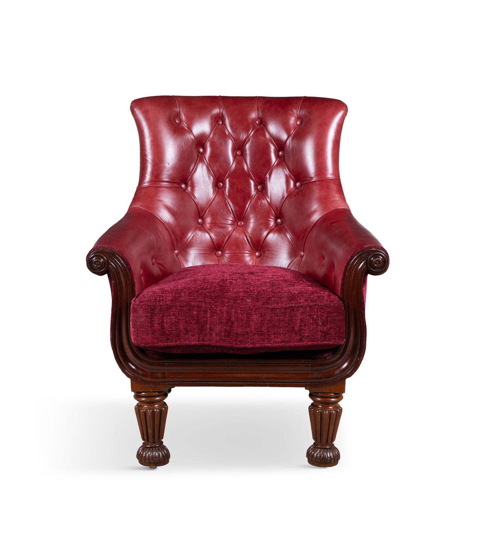 A GEORGE IV MAHOGANY FRAMED BUTTON BACK LIBRARY ARMCHAIR, the tub back and outscrolling arms: A GEORGE IV MAHOGANY FRAMED BUTTON BACK LIBRARY ARMCHAIR, the tub back and outscrolling arms covered in red leather, with channelled seat rail and uprights ending in roundels, supported on fluted tape