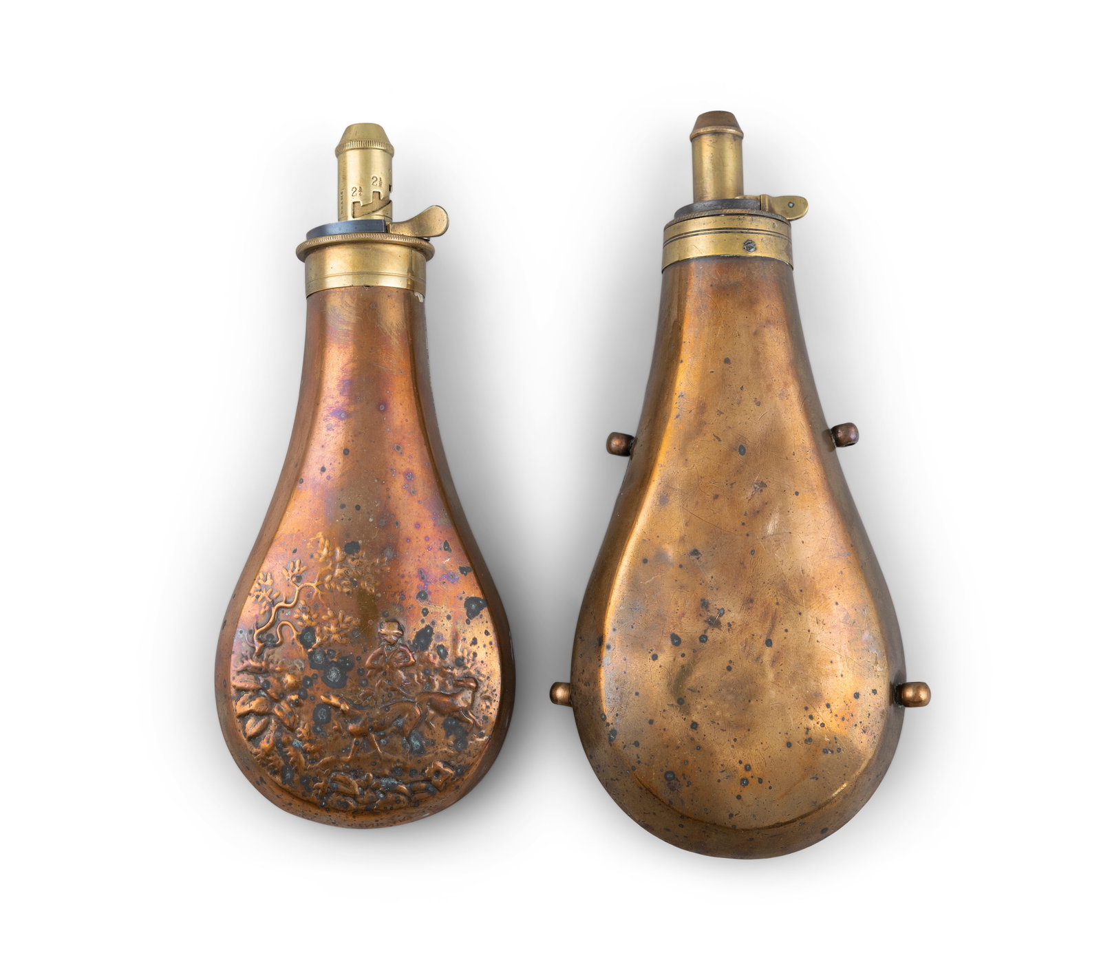 TWO LARGE COPPER POWDER FLASKS, 19TH CENTURY with brass mounts, one with embossed decoration. (1 of 3)