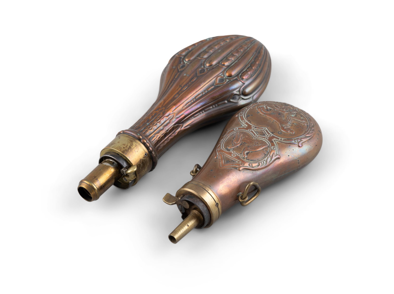 TWO COPPER POWDER FLASKS, 19TH CENTURY with embossed decoration and brass mounts. (1 of 2)