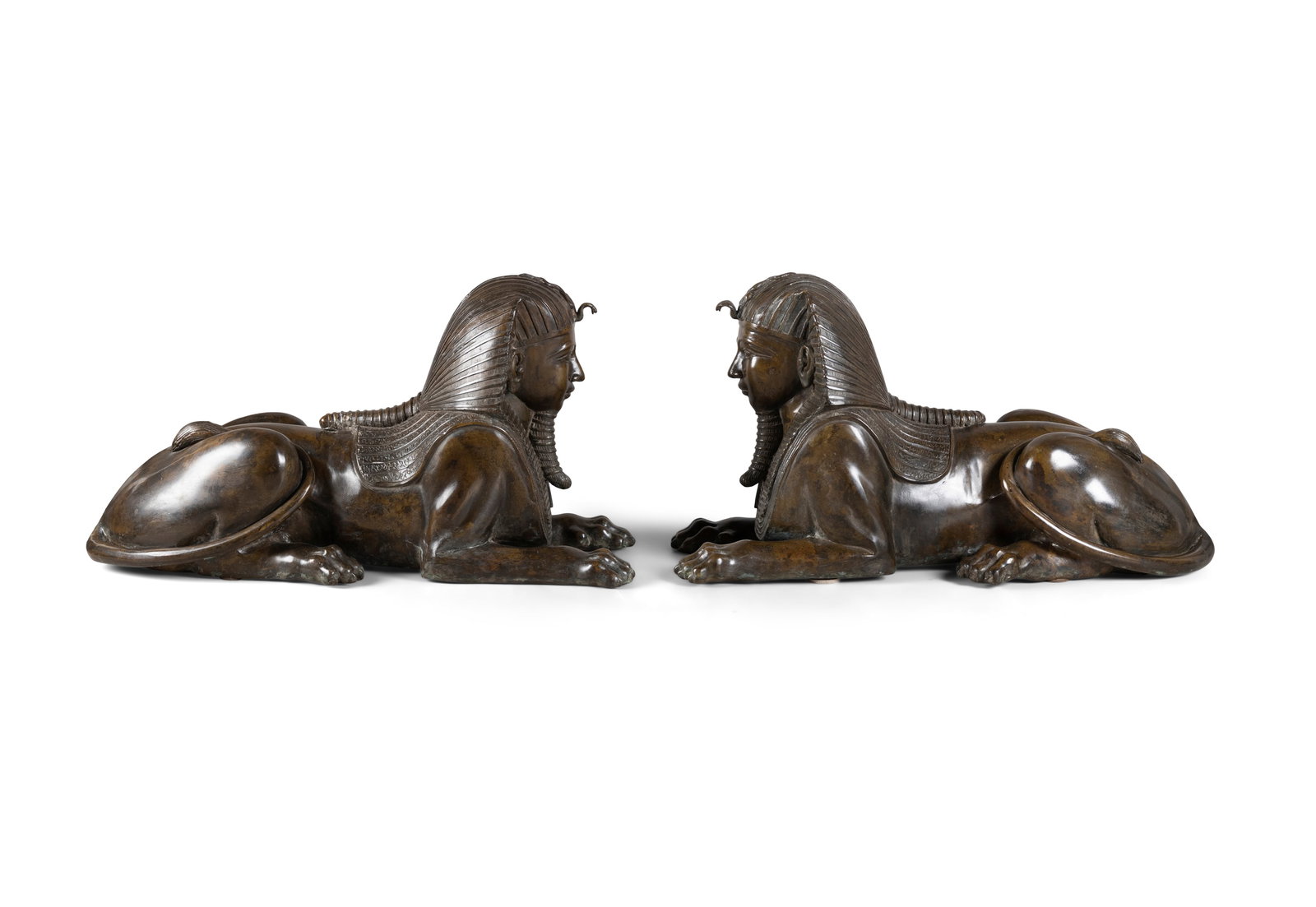 A PAIR OF BRONZE MODELS OF EGYPTIAN SPHINXES, each recumbent, 67cm long: A PAIR OF BRONZE MODELS OF EGYPTIAN SPHINXES, each recumbent, 67cm long