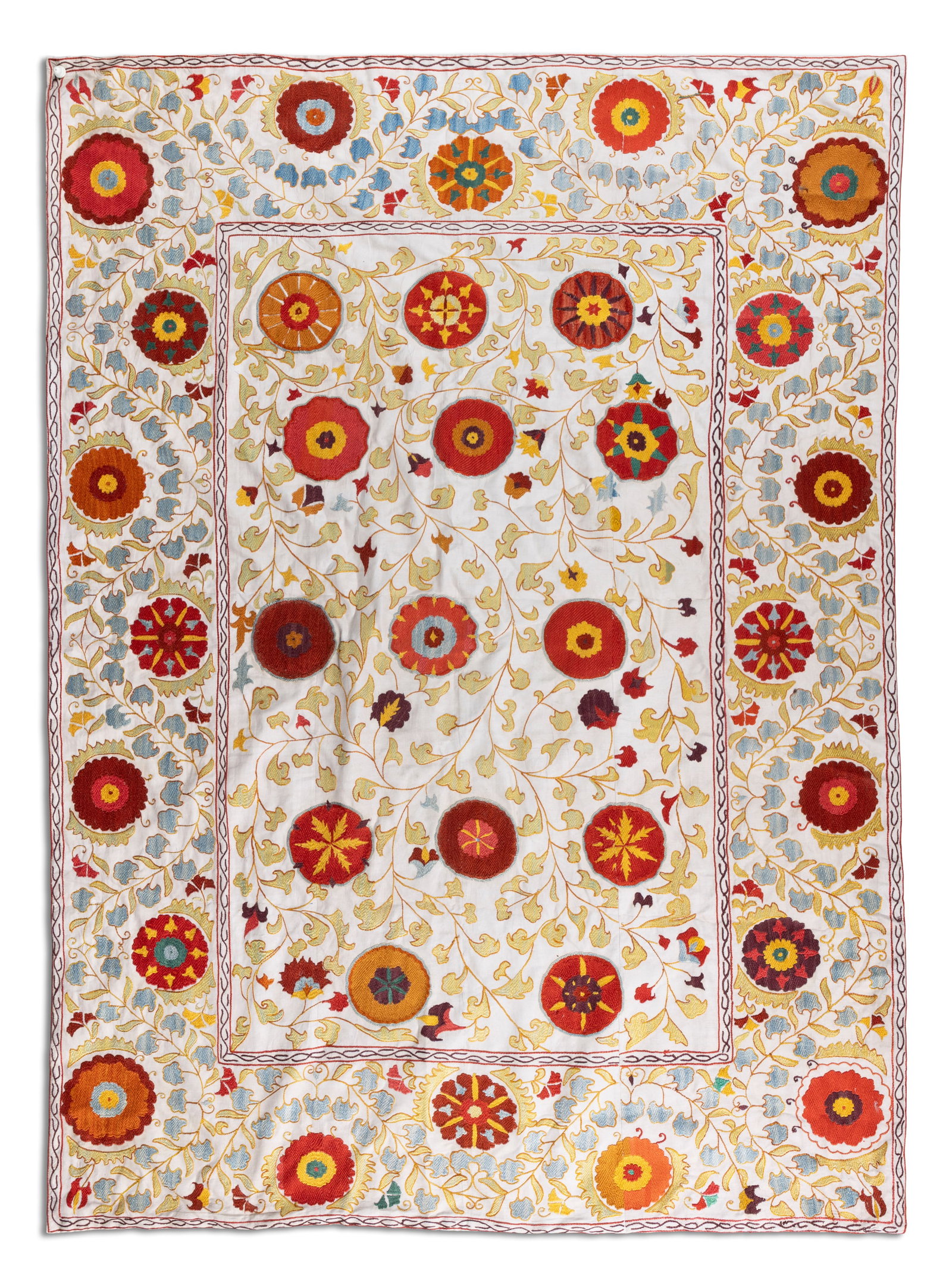 A SILK UZBEK SUZANI, UZBEKISTAN, EARLY 20th CENTURY, 187 × 138cm, embroidered with large: A SILK UZBEK SUZANI, UZBEKISTAN, EARLY 20th CENTURY, 187 × 138cm, embroidered with large circular rosettes in shades of saffron, red, purple, and light blue, linked by delicate tendrils and leafy