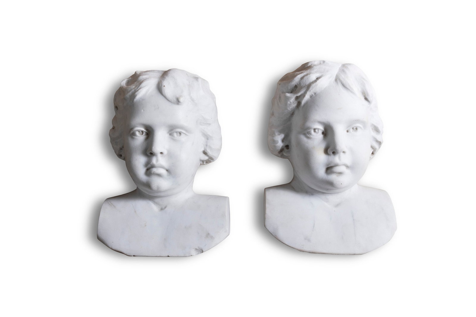 A PAIR OF WHITE MARBLE CHERUB HEADS, originally part of a fire surround, circa 31 cm high x 21cm: A PAIR OF WHITE MARBLE CHERUB HEADS, originally part of a fire surround, circa 31 cm high x 21cm wide