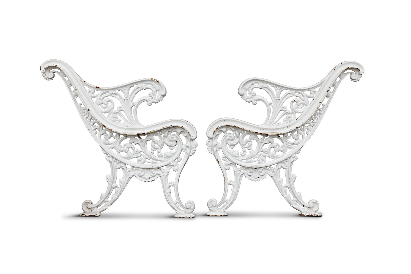A PAIR OF VICTORIAN WHITE-PAINTED CAST IRON GARDEN BENCH ENDS, each with pierced foliate scroll (1 of 4)