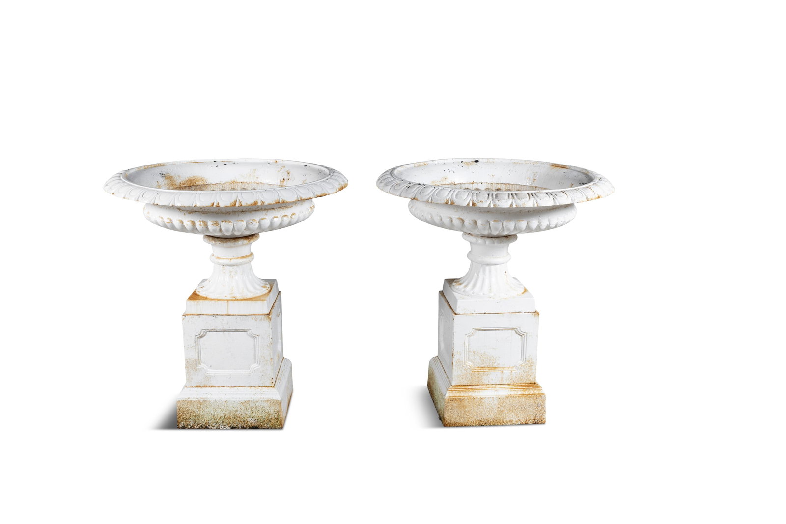 A PAIR OF WHITE PAINTED CAST IRON GARDEN URNS, of campagna form with out-turned rims, squashed: A PAIR OF WHITE PAINTED CAST IRON GARDEN URNS, of campagna form with out-turned rims, squashed demi-fluted bodies, on waisted socle, plinth base, each raised on square pedestals. 92cm high, 82cm diame