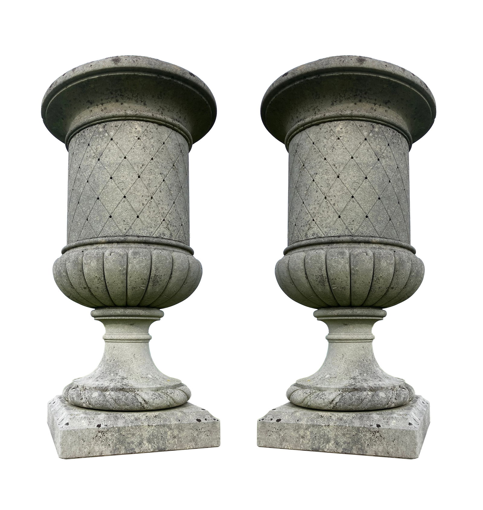 A LARGE PAIR OF CLASSICAL STONE URNS, each with pointed finials, the demi fluted bodies decorated: A LARGE PAIR OF CLASSICAL STONE URNS, each with pointed finials, the demi fluted bodies decorated with trellis pattern, on waisted socles and square pedestal bases. Approx. 8ft high